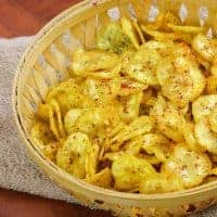 How to make Banana Chips Recipe | Evening Snacks Banana Chips on a wooden basket full of banana chips kept on a handkerchief on wooden surface |