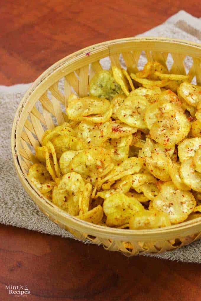 Banana Chips on a wooden basket full of banana chips kept on a handkerchief on wooden surface | Banana Chips on a wooden basket full of banana chips kept on a handkerchief on wooden surface |