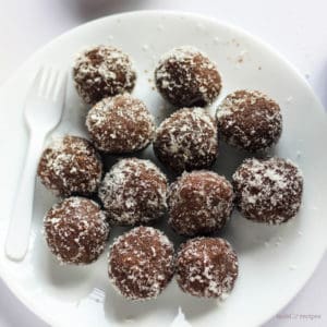 चॉकलेट नारियल बॉल्स कैसे बनाते है | Chocolate Coconut Balls Recipe In Hindi Chocolate coconut balls on a white plate garnished with some dessicated coconut