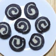 12 Tasty and Easy Cake Recipes Chocolate Swiss Rolls on a white plate decorated round kept on a wooden surface|
