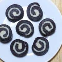 No Bake Chocolate Swiss Roll Chocolate Swiss Rolls on a white plate decorated round kept on a wooden surface|