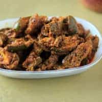 How To make Mango Pickle At Home - Mango Pickle Recipe - Aam Ka Achaar Mango Pickle on a white plate on a green surface |