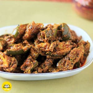 आम का आचार बनाने की विधि | Mango Pickle Recipe in Hindi Mango Pickle on a white plate on a green surface |