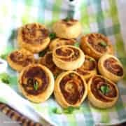 22 Namkin Snacks Pinwheel Samosa on a basket, garnished with some chopped coriander leaves