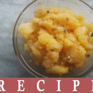 Aloo ka Halwa on transparent bowl and some cardamom powder for garnish keeped on a marble surface|