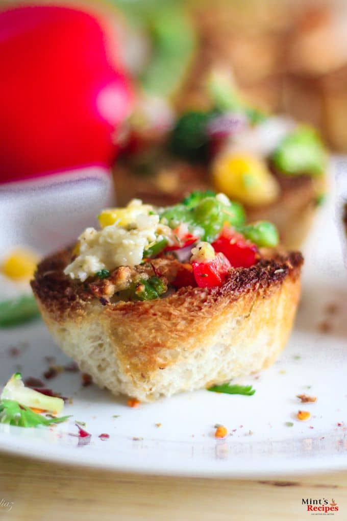 Baked Veg Bread Pizza on a plate with some parsley leafs. stuffing of veggies in the tokri