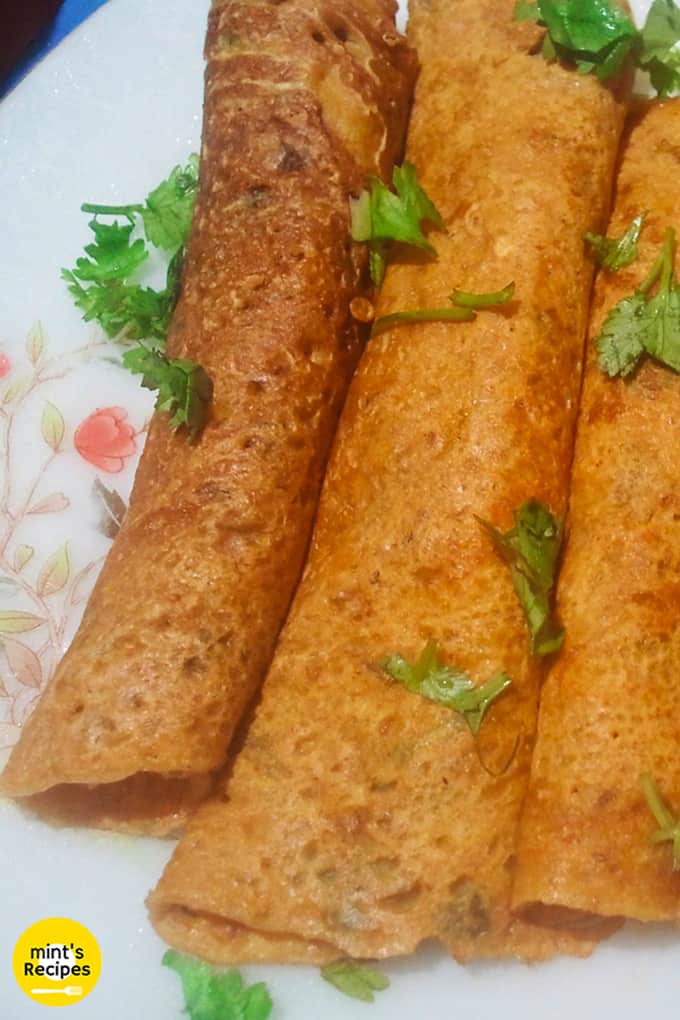 Besan ka chilla on a floural print plate with some garnishing of coriander leaves