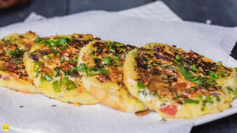 Bread Moongdal Uttapam on a white plate in absorbent paper