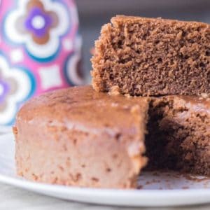 Chocolate biscuit on a white plate with a slice of cake on the top of rest the cake |