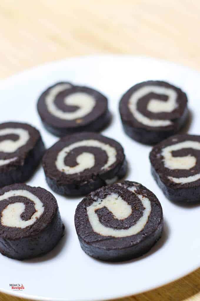 Chocolate Swiss Rolls on a white plate decorated round kept on a wooden surface|
