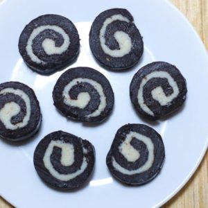 Chocolate Swiss Rolls on a white plate decorated round kept on a wooden surface|
