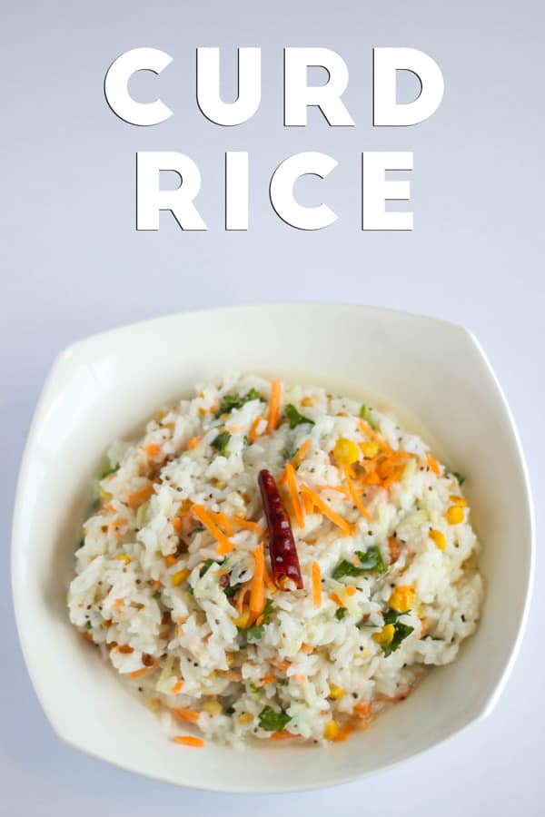 Curd Rice on a white tray with some grated carrot