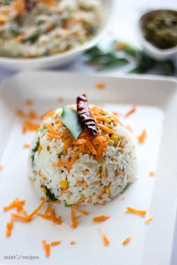 Curd Rice on a white tray with some grated carrot