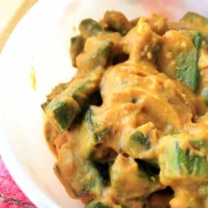 Dahi Bhindi on a white bowl put on a red surface. it's quick and very easy recipes to make at home |