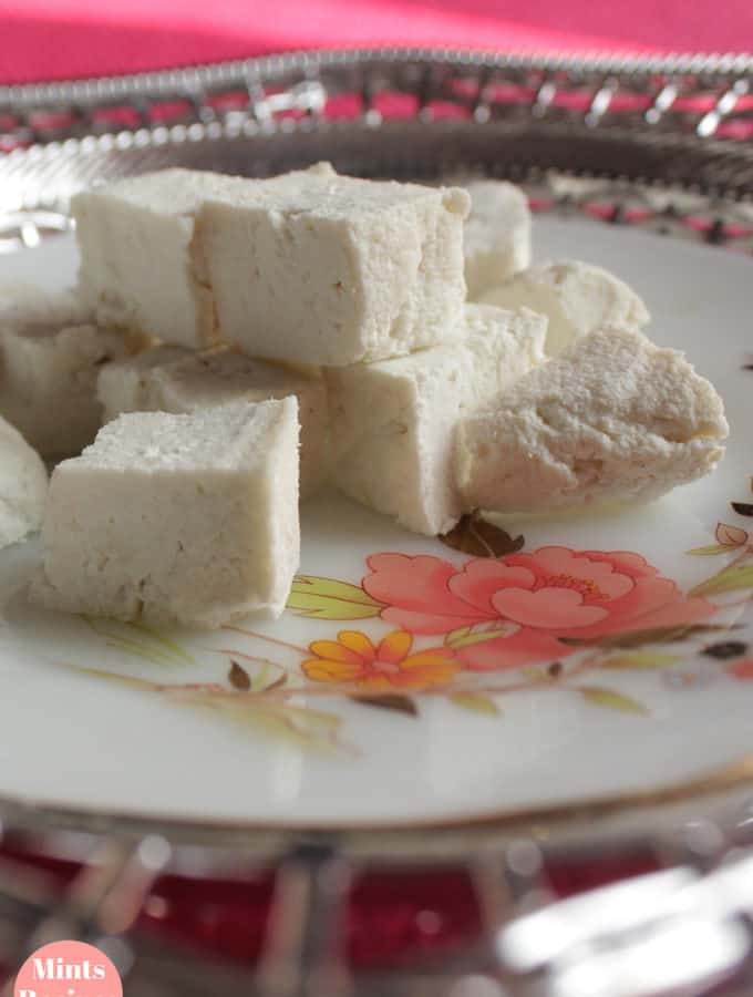 Paneer cutted into cubes on a silver coloured plate