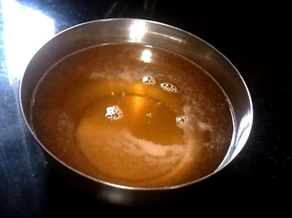 Ghee on a steel bowl with bowl full of ghee keeped on a dark background under sun light |