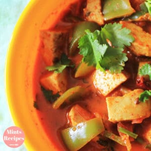 Kadhai Paneer on a yellow bowl with lots of veggies and garnished with coriander leaves