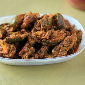 Mango Pickle on a white plate on a green surface |
