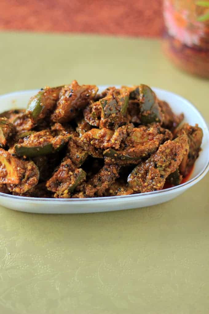 Mango Pickle on a white plate on a green surface |