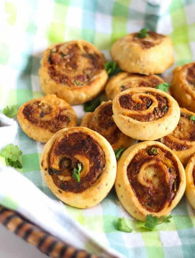 Pinwheel Samosa on a basket, garnished with some chopped coriander leaves