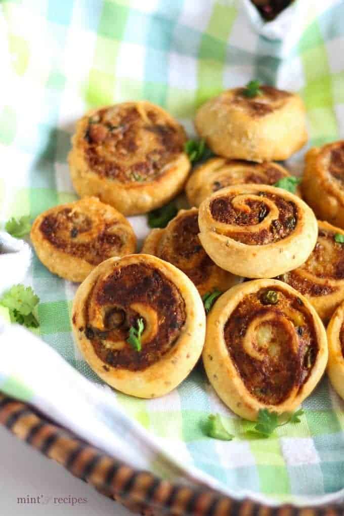 Pinwheel Samosa on a basket, garnished with some chopped coriander leaves 