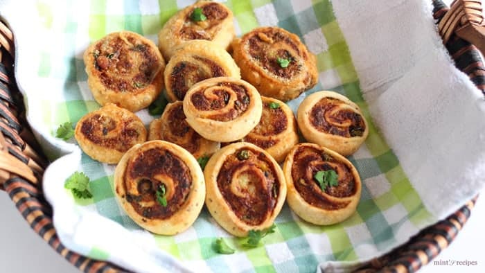 Pinwheel Samosa on a basket, garnished with some chopped coriander leaves