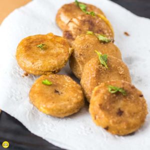 Potato Cheese Corn Rolls| Potato cheese corn rolls on a white plate with an absorbing paper and some coriander leaves to garnish |