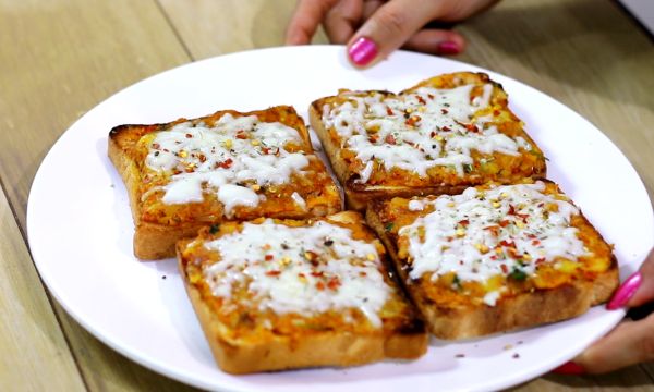 Potato cheese toast on a white plate with some potato mixture and grated cheese with some italian seasoning and red chilli flakes| www.mintsrecipes.com |