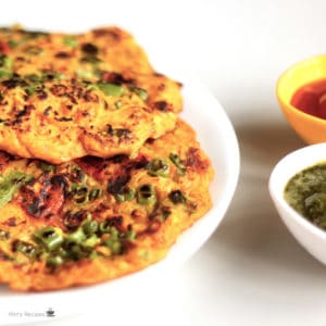 Potato Lachcha Pancake on a white plate with some pancakes on it and garnished with some coriander leaves