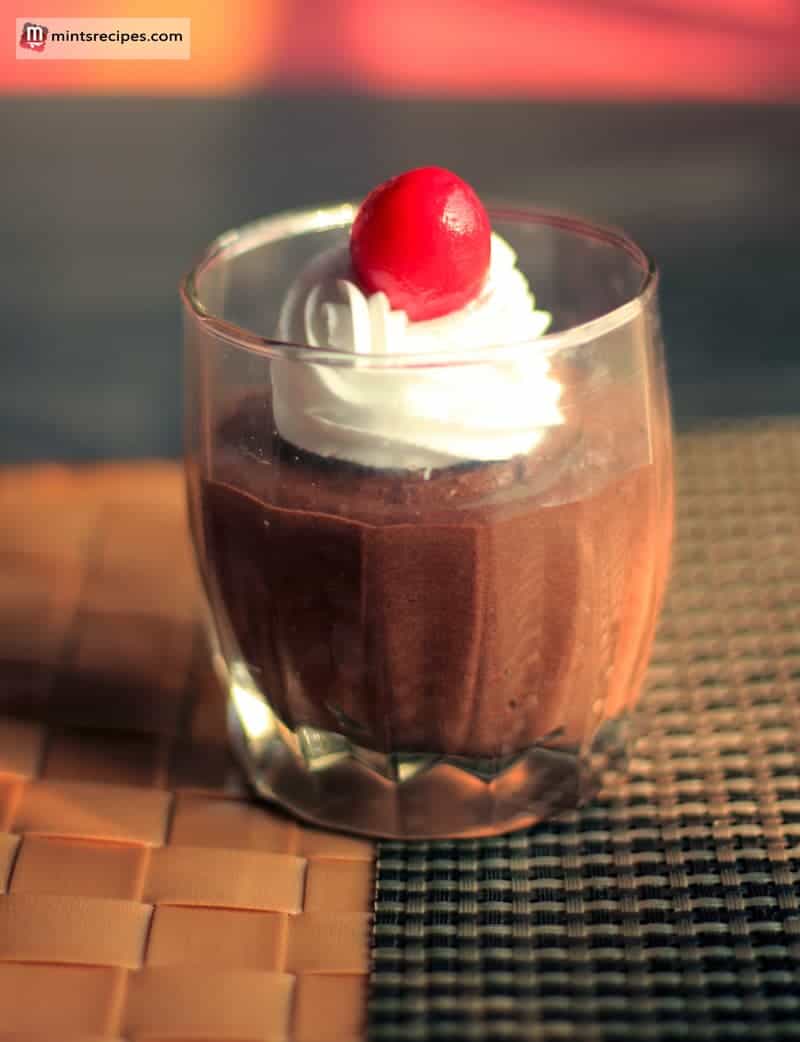 Chocolate Mousse on a glass with some whipped cream 