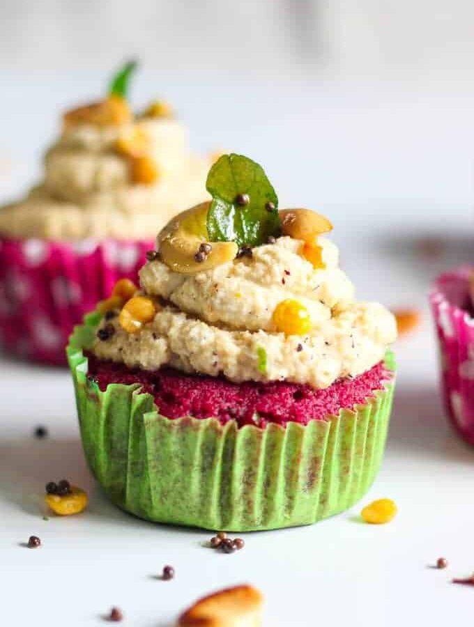 Red Velvet Idli Cupcake on a white surface with tempering of coconut chutney and little tempering of curry leaves, mustard seed, chana dal and cashew |