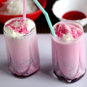 Rose Milkshake on a glass filled with rose milkshake and vanilla ice cream with vermicelli and a stow in it|