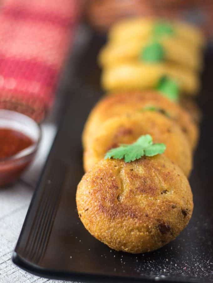 Suji ki kachori on a white plate with some green chutney garnish with coriander leaves