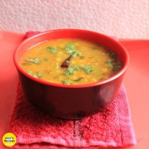 Turai chana dal on a red bowl garnished with some coriander