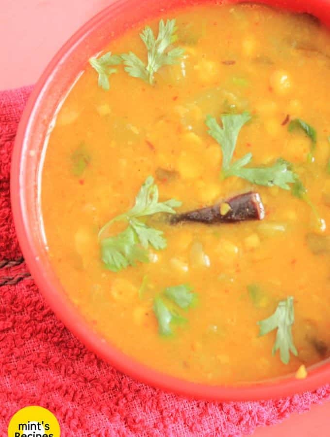 Turai chana dal on a red bowl garnished with some coriander