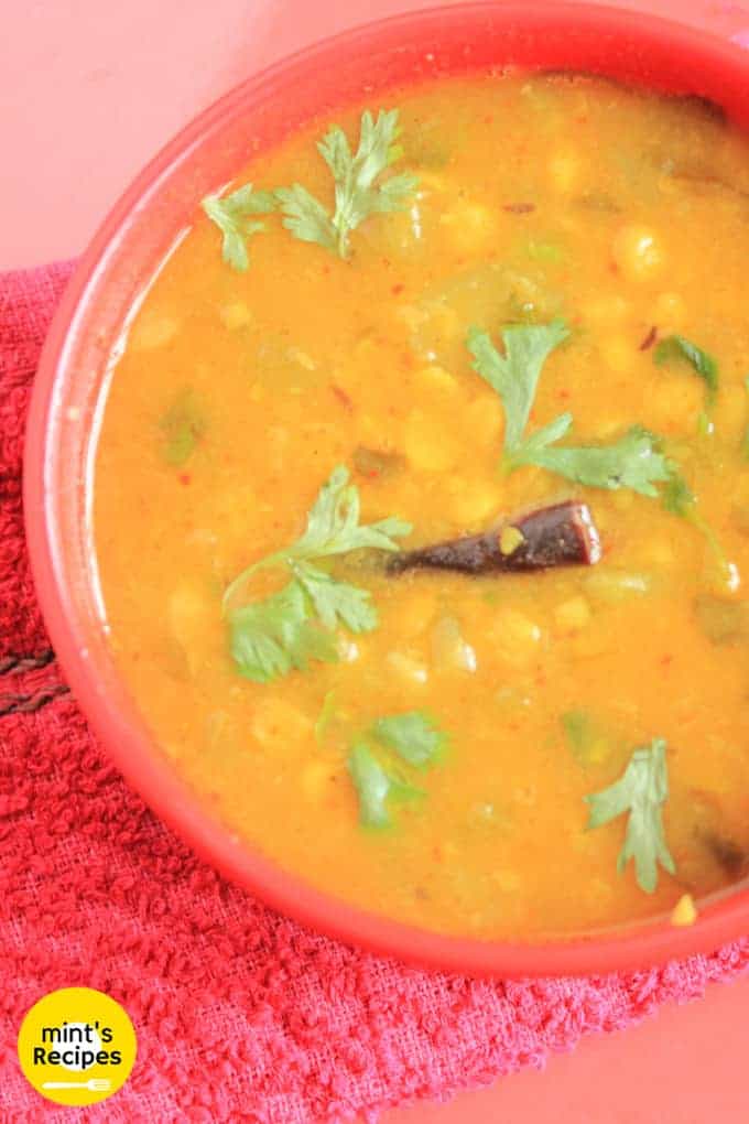 Turai chana dal on a red bowl garnished with some coriander 