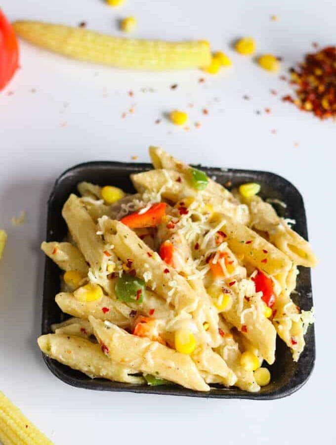 Italian white Sauce Pasta with some chilli flakes, grated cheese and Italian seasoning