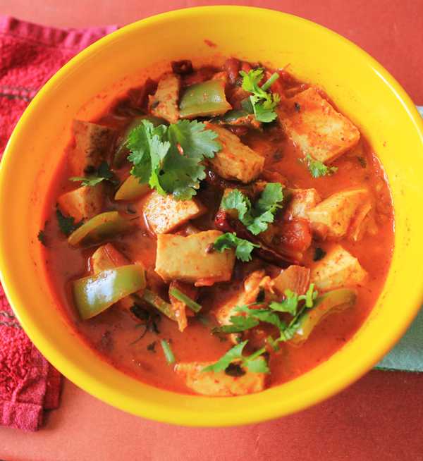 Kadhai Paneer on a yellow bowl with lots of veggies and garnished with coriander leaves 